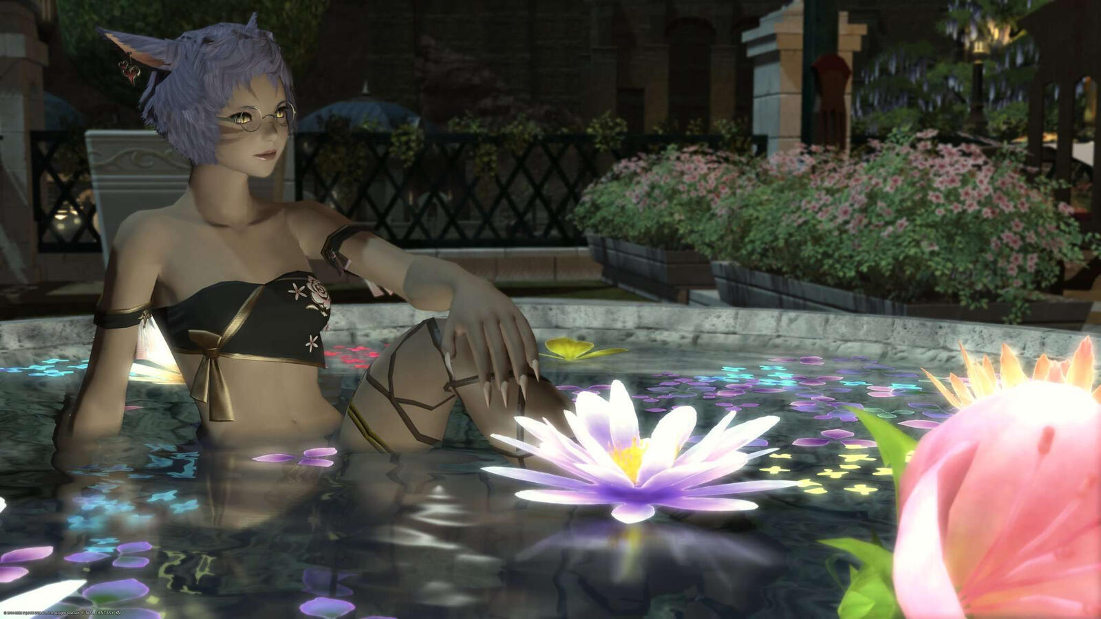 K'anra sitting in a pond with flowers floating in it.